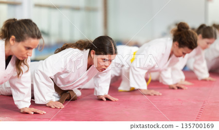 Women doing push-ups in training Women doing push-ups in training 135700169