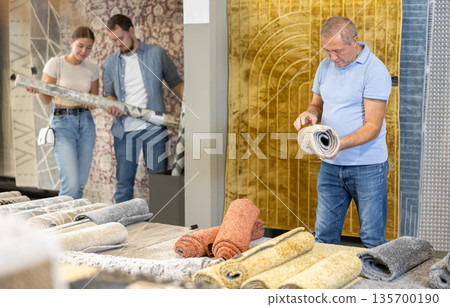 Elderly male buyer chooses soft carpet to create coziness in her apartment Elderly male buyer chooses soft carpet to create coziness in her apartment 135700190
