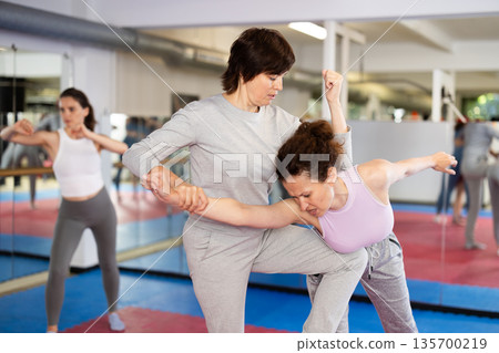 Women practicing gifts in self-defense training 135700219