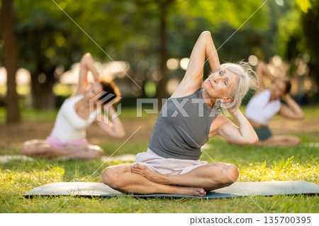 Elderly woman doing yoga in lotus position Elderly woman doing yoga in lotus position 135700395