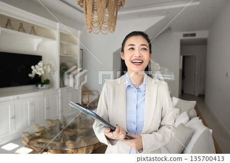 Laughing real-estate agent posing in contemporary living room 135700413