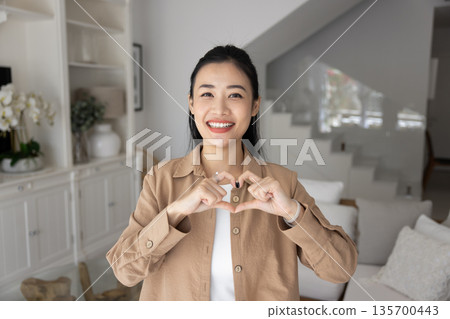 Woman showing symbol of love and affection with joined fingers Woman showing symbol of love and affection with joined fingers 135700443
