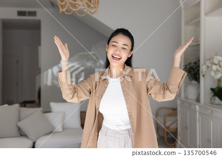 Woman dancing and singing in modern living room 135700546
