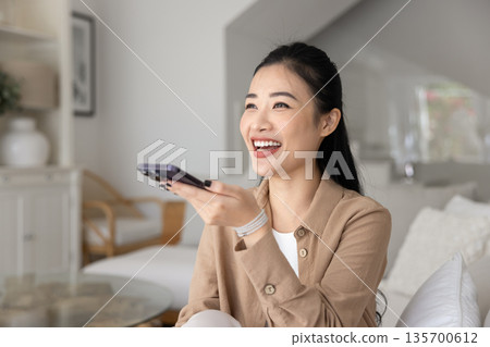 Young 30s Asian woman make hands-free phone call Young 30s Asian woman make hands-free phone call 135700612