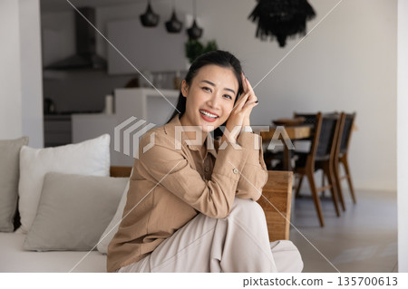 Portrait of attractive woman looking at camera with joyful expression 135700613