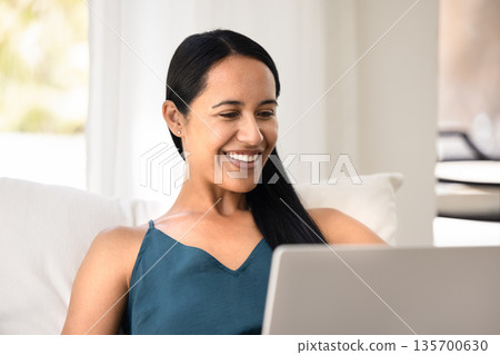 Cheerful relaxed young Maori woman using multimedia service on laptop Cheerful relaxed young Maori woman using multimedia service on laptop 135700630