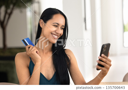 New Zealander woman using Internet bank service on mobile phone New Zealander woman using Internet bank service on mobile phone 135700643