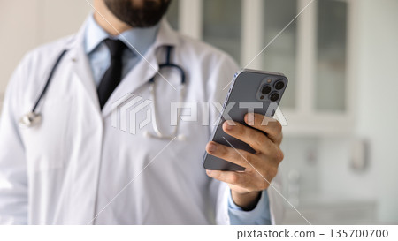 Close up banner shot of smartphone in hand of doctor Close up banner shot of smartphone in hand of doctor 135700700
