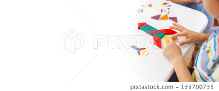 Child Playing with Colorful Tangram Puzzle on White Table Child Playing with Colorful Tangram Puzzle on White Table 135700735