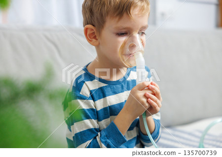 Young Child Using Nebulizer for Breathing Treatment at Home 135700739