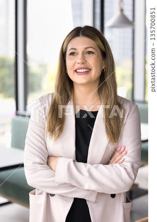Smiling mature businesswoman standing in calm confident pose looking away Smiling mature businesswoman standing in calm confident pose looking away 135700851