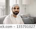 Young Middle-Eastern man in traditional Muslim wear looking at camera 135701027
