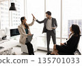 Two happy teammates exchanging high-five gesture in coworking office 135701033
