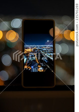 透過智慧型手機看到的夜景城市景觀 透過智慧型手機看到的夜景城市景觀 135701269