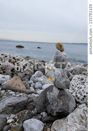 Balancing art made of piled stones on the beach Balancing art made of piled stones on the beach 135701329