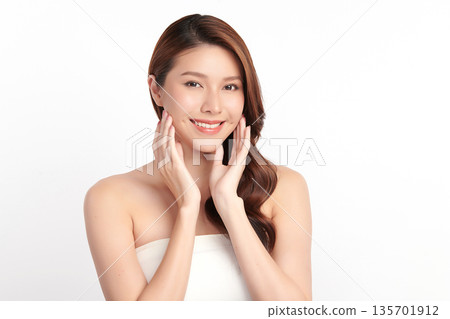 A beautiful young Asian woman with clean, fresh skin against a white background. Skincare, facial treatment, cosmetology, beauty, and spa. An elegant portrait of an Asian woman. 135701912