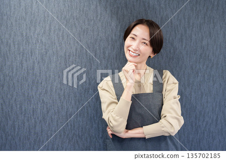 一位穿著圍裙、正在思考的女職員 135702185