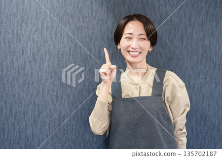 一位穿著圍裙的女店員指著 135702187