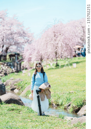 woman tourist sightseeing Kitakami Tenshochi Park with Sakura Cherry Blossom in Spring, traveler travel in Kitakami festival, Iwate prefecture, Japan. Landmark for Travel and Vacation destination woman tourist sightseeing Kitakami Tenshochi Park with Sakura Cherry Blossom in Spring, traveler travel in Kitakami festival, Iwate prefecture, Japan. Landmark for Travel and Vacation destination 135702251