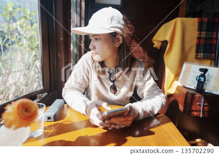 Young Asian woman using smartphone during relaxing in coffee cafe shop. Have a Nice day concept 135702290