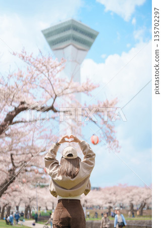 Woman tourist sightseeing Goryokaku Tower park with Sakura Cherry Blossom in Spring, happy traveler travel in Hakodate city, Hokkaido, Japan. famous Landmark, Japan Travel and Vacation destination 135702297