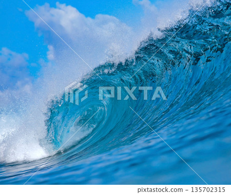 Blue wave breaking on a beach in sea Blue wave breaking on a beach in sea 135702315