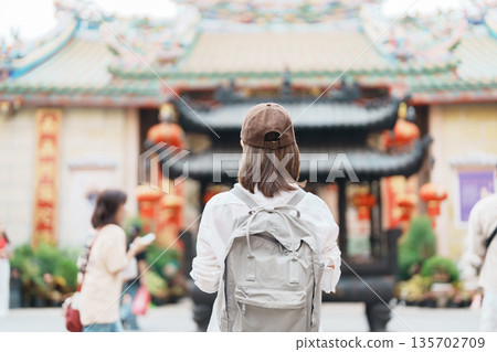 Woman traveling in Wat Mangkorn Kammalawas, Leng Nuei Yee as Chinese temple. Asian traveler visiting at Yaowarat road or Chinatown of Bangkok, landmark and popular for tourist attractions in Thailand 135702709