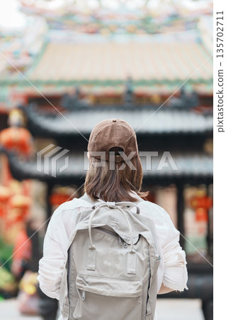 Woman traveling in Wat Mangkorn Kammalawas, Leng Nuei Yee as Chinese temple. Asian traveler visiting at Yaowarat road or Chinatown of Bangkok, landmark and popular for tourist attractions in Thailand 135702711