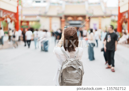 Woman traveling in Wat Mangkorn Kammalawas, Leng Nuei Yee as Chinese temple. Asian traveler visiting at Yaowarat road or Chinatown of Bangkok, landmark and popular for tourist attractions in Thailand 135702712
