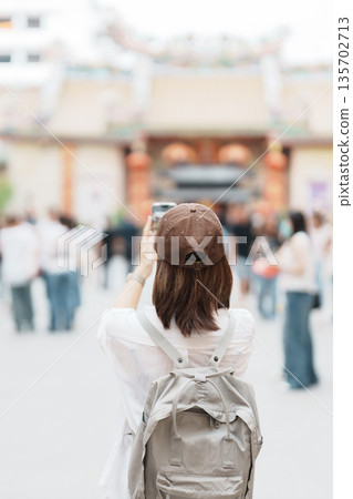 Woman traveling in Wat Mangkorn Kammalawas, Leng Nuei Yee as Chinese temple. Asian traveler visiting at Yaowarat road or Chinatown of Bangkok, landmark and popular for tourist attractions in Thailand 135702713