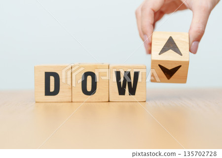 Hand change wooden block of Dow Jones Index text to UP and Down arrow symbol icon. stock market index, trade, trade company in the United States, financial growth and Cut loss concept Hand change wooden block of Dow Jones Index text to UP and Down arrow symbol icon. stock market index, trade, trade company in the United States, financial growth and Cut loss concept 135702728