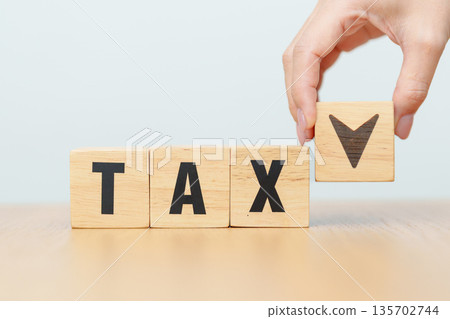 hand change wooden block with TAX text to UP and Down arrow icon. decrease and Increase, Taxpayer, Taxable Income, Tax Filing, Deduction, Withholding Tax, WHT, VAT, Computation and Exemption concept 135702744