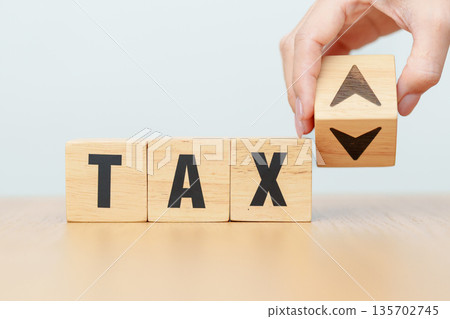 hand change wooden block with TAX text to UP and Down arrow icon. decrease and Increase, Taxpayer, Taxable Income, Tax Filing, Deduction, Withholding Tax, WHT, VAT, Computation and Exemption concept 135702745
