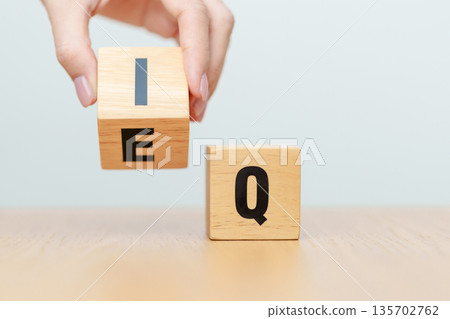 hand change wooden block from IQ to EQ, balance between intelligence quotient and emotional quotient, AQ Adversity, MQ, Moral, SQ and Social quotient concepts 135702762