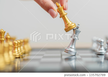 hand moving gold Chess King figure and Checkmate opponent during chessboard competition. Strategy, Success, management, business planning, win, disruption, Trade war and leadership concept hand moving gold Chess King figure and Checkmate opponent during chessboard competition. Strategy, Success, management, business planning, win, disruption, Trade war and leadership concept 135702789