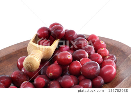 Fresh Red Cranberries in Wooden Scoop on Wooden Plate for Health, Food, and Holiday Meals 135702988