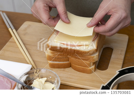 Hands making a hot sandwich with a hot sandwich maker 135703081