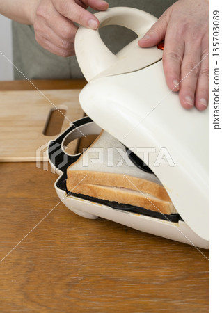 雙手用熱三明治機製作熱三明治 135703089