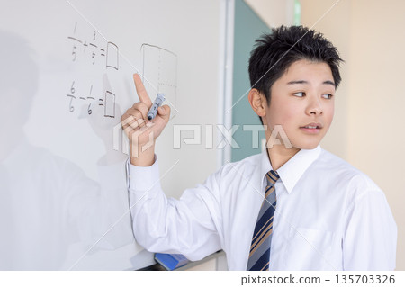 Student writing fractions on a whiteboard Student writing fractions on a whiteboard 135703326