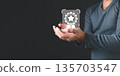 A person in a gray sweater holds a glowing digital icon of a certificate badge with a star, symbolizing quality, trust, and achievement in modern business standards and recognition. 135703547