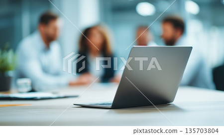 Group of people discussing ideas while working on a laptop in a modern office environment during the day time Group of people discussing ideas while working on a laptop in a modern office environment during the day time 135703804