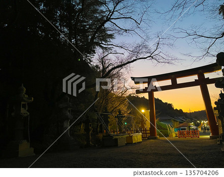 A shrine at twilight, silhouette of a torii gate against a beautiful sunset A shrine at twilight, silhouette of a torii gate against a beautiful sunset 135704206