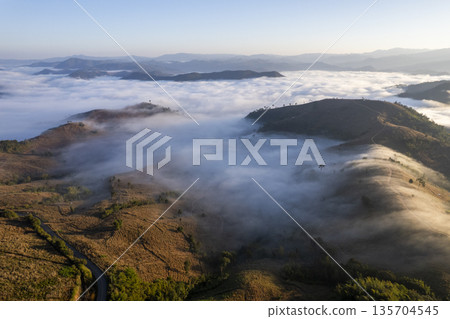 Landscape of Morning Mist with Mountain Layer. mountain ridge and clouds in rural jungle bush forest Landscape of Morning Mist with Mountain Layer. mountain ridge and clouds in rural jungle bush forest 135704545