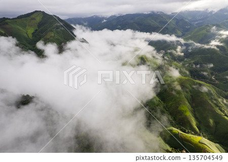 Landscape of Morning Mist with Mountain Layer. mountain ridge and clouds in rural jungle bush forest Landscape of Morning Mist with Mountain Layer. mountain ridge and clouds in rural jungle bush forest 135704549