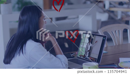 Woman wearing white top viewing whiteboard on laptop in office space, with color swatch, copy space 135704941