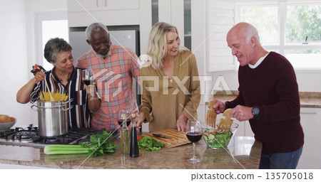 Cooking meal by four adults at home kitchen island, using spaghetti pot and salad bowl Cooking meal by four adults at home kitchen island, using spaghetti pot and salad bowl 135705018