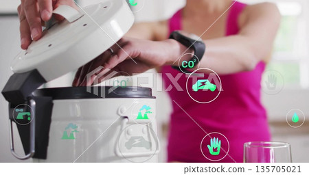 Korean woman in pink top lifting cooker lid on kitchen countertop, with smart home icons 135705021
