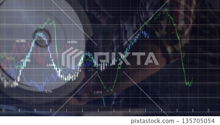 Analyzing man in plaid shirt tracking financial charts at laptop in home office, with desk lamp Analyzing man in plaid shirt tracking financial charts at laptop in home office, with desk lamp 135705054