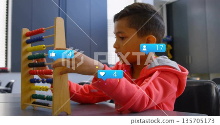 Counting boy wearing red sweatshirt moving beads on wooden abacus in classroom, with overlay icons Counting boy wearing red sweatshirt moving beads on wooden abacus in classroom, with overlay icons 135705173