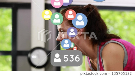 Leaning woman in pink top, gray sports bra focusing in gym, with floating avatars, 536 overlay Leaning woman in pink top, gray sports bra focusing in gym, with floating avatars, 536 overlay 135705182